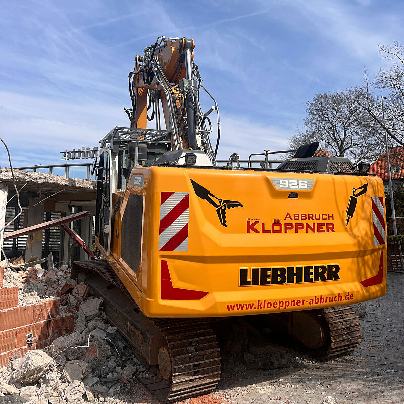 Gelber Abbruchbagger an einer Baustelle