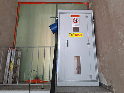 Hauseingang im Treppenhaus, der mit Schutzfolie zugehangen ist